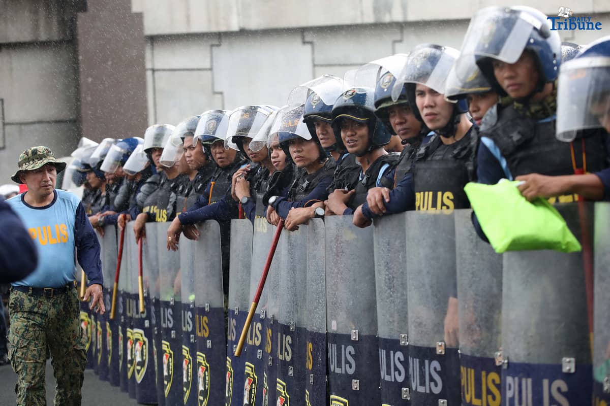 Members of the Philippine National Police (PNP) guard Commonwealth Avenue near St. Peter Church in Quezon City to block militant groups during President Ferdinand Marcos Jr.’s fourth State of the Nation Address.