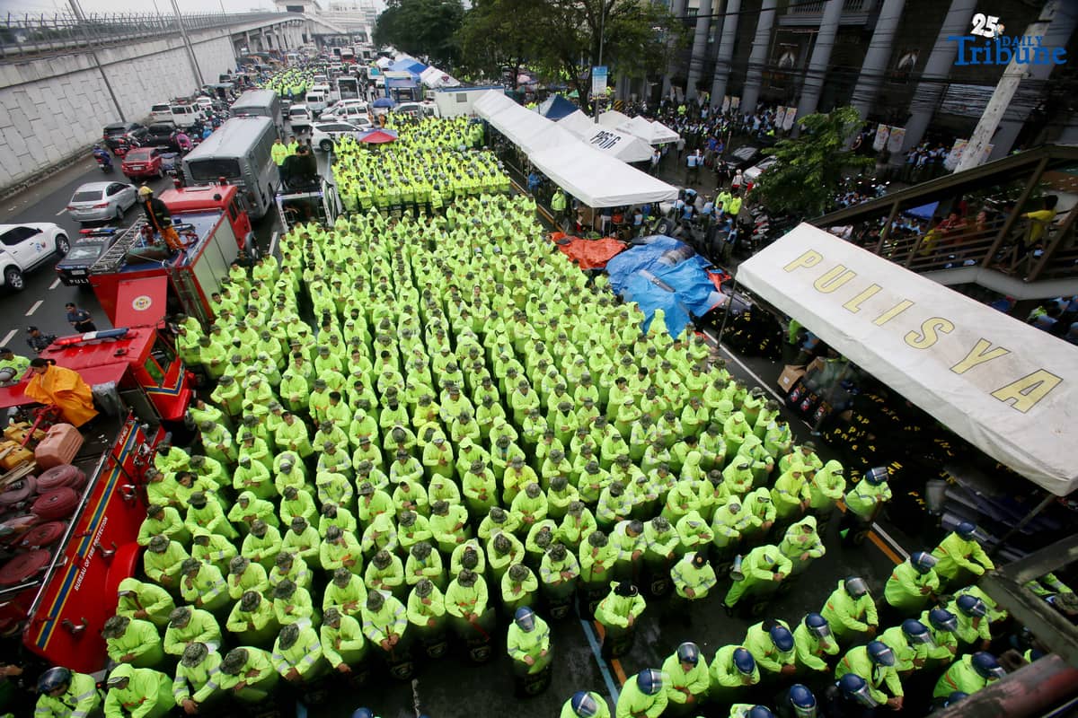 Members of the Philippine National Police (PNP) guard Commonwealth Avenue near St. Peter Church in Quezon City to block militant groups during President Ferdinand Marcos Jr.’s fourth State of the Nation Address.