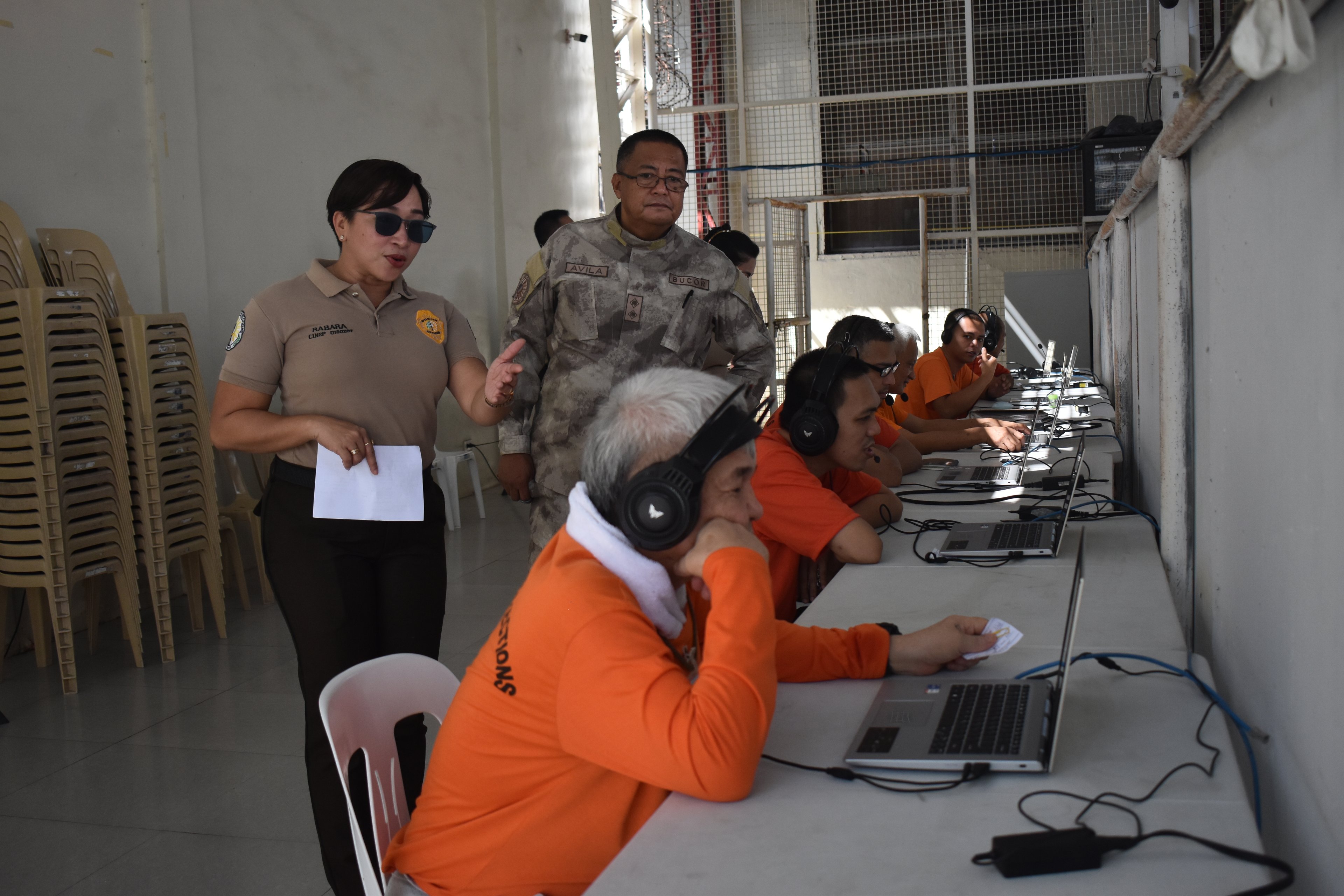 BuCor personnel assists selected inmates navigate the Electronic Dalaw (E-Dalaw) online visitation program using laptops.