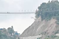 PEOPLE walk across a footbridge at a landslide-prone area near the Arniko Highway in Nepal’s Kavre district.