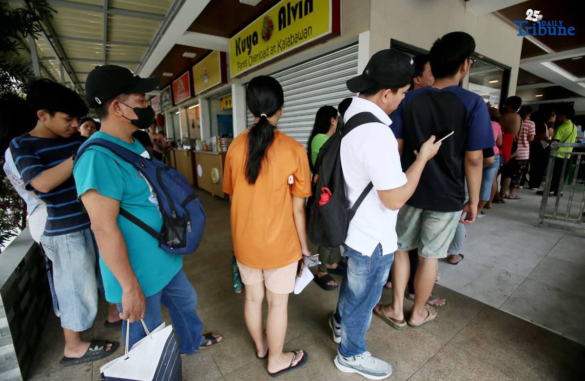 Residents line up at a satellite voters' registration center in Barangay Commonwealth, Quezon City on Tuesday in preparation for the upcoming Barangay and Sangguniang Kabataan Elections (BSKE).
