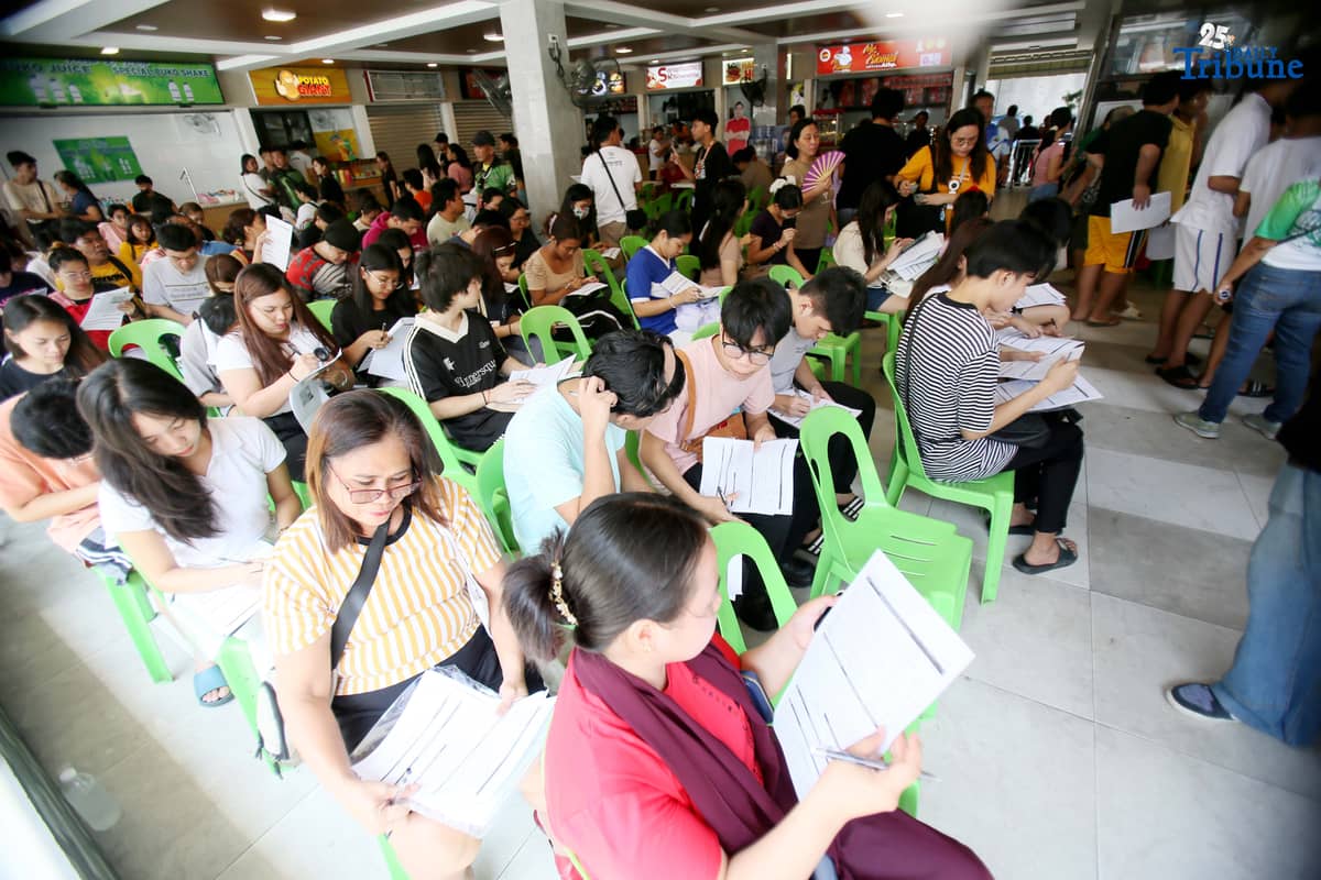 Residents line up at a satellite voters' registration center in Barangay Commonwealth, Quezon City on Tuesday in preparation for the upcoming Barangay and Sangguniang Kabataan Elections (BSKE).