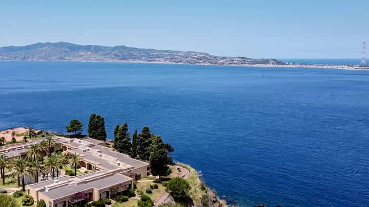 A general aerial view shows the Sicilian coast towards Cape Torre Faro, over the Strait of Messina, taken from the outskirts of the town of Scilla, in Calabria region in southern Italy, on July 7, 2020. Italy's government on August 6, 2025 approved a 13.5-billion-euro ($15.6-billion) project to build the world's longest suspension bridge connecting the island of Sicily to the mainland.