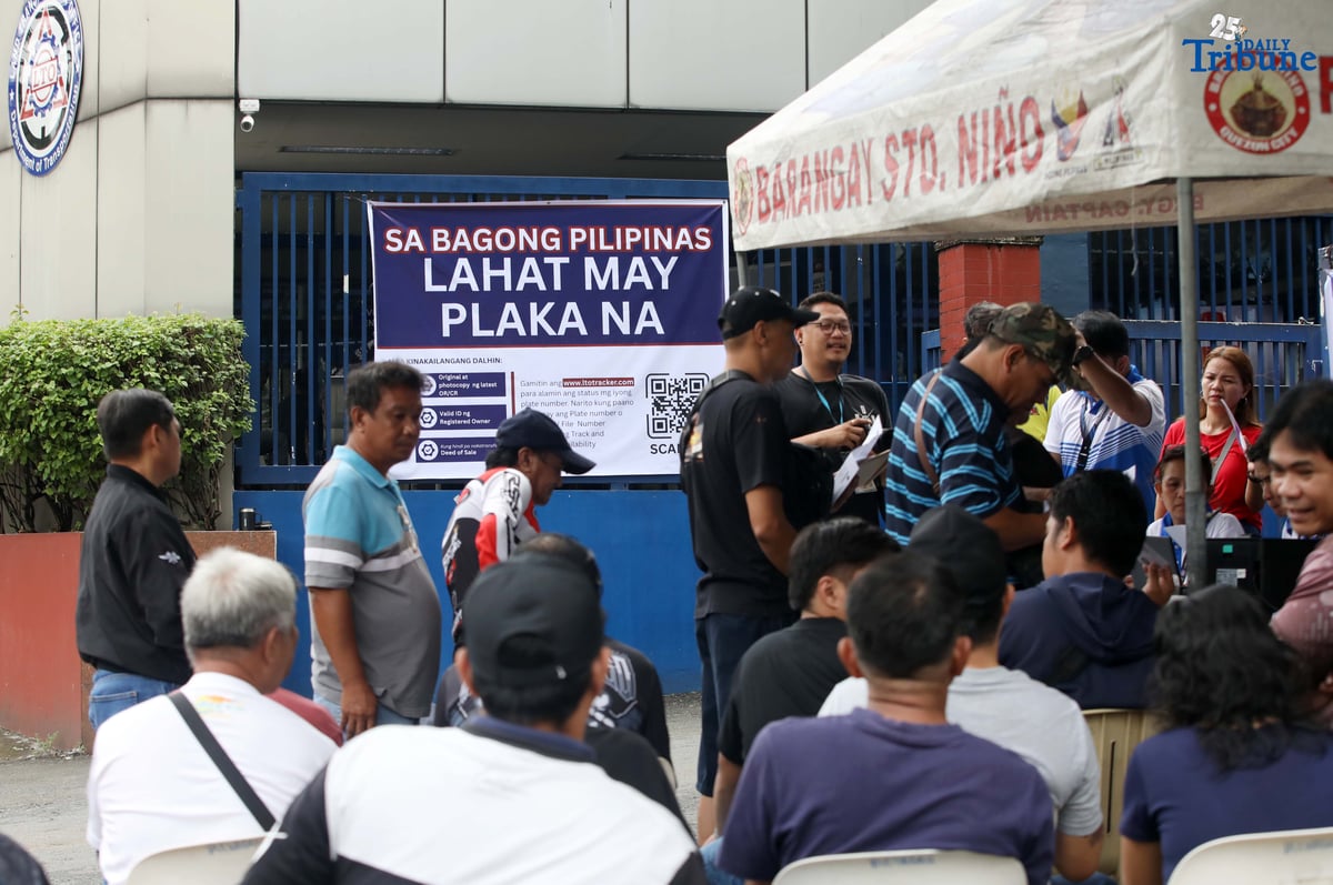 The Land Transportation Office Law Enforcement Unit assists motorcycle owners queuing for the LTO Palit Plaka program at the LTO main office along East Avenue in Quezon City on Saturday. The nationwide plate distribution program aims to address the backlog and ensure motorists comply with registration requirements.
