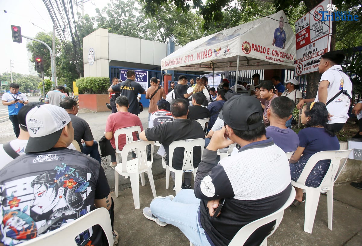 The Land Transportation Office Law Enforcement Unit assists motorcycle owners queuing for the LTO Palit Plaka program at the LTO main office along East Avenue in Quezon City on Saturday. The nationwide plate distribution program aims to address the backlog and ensure motorists comply with registration requirements.