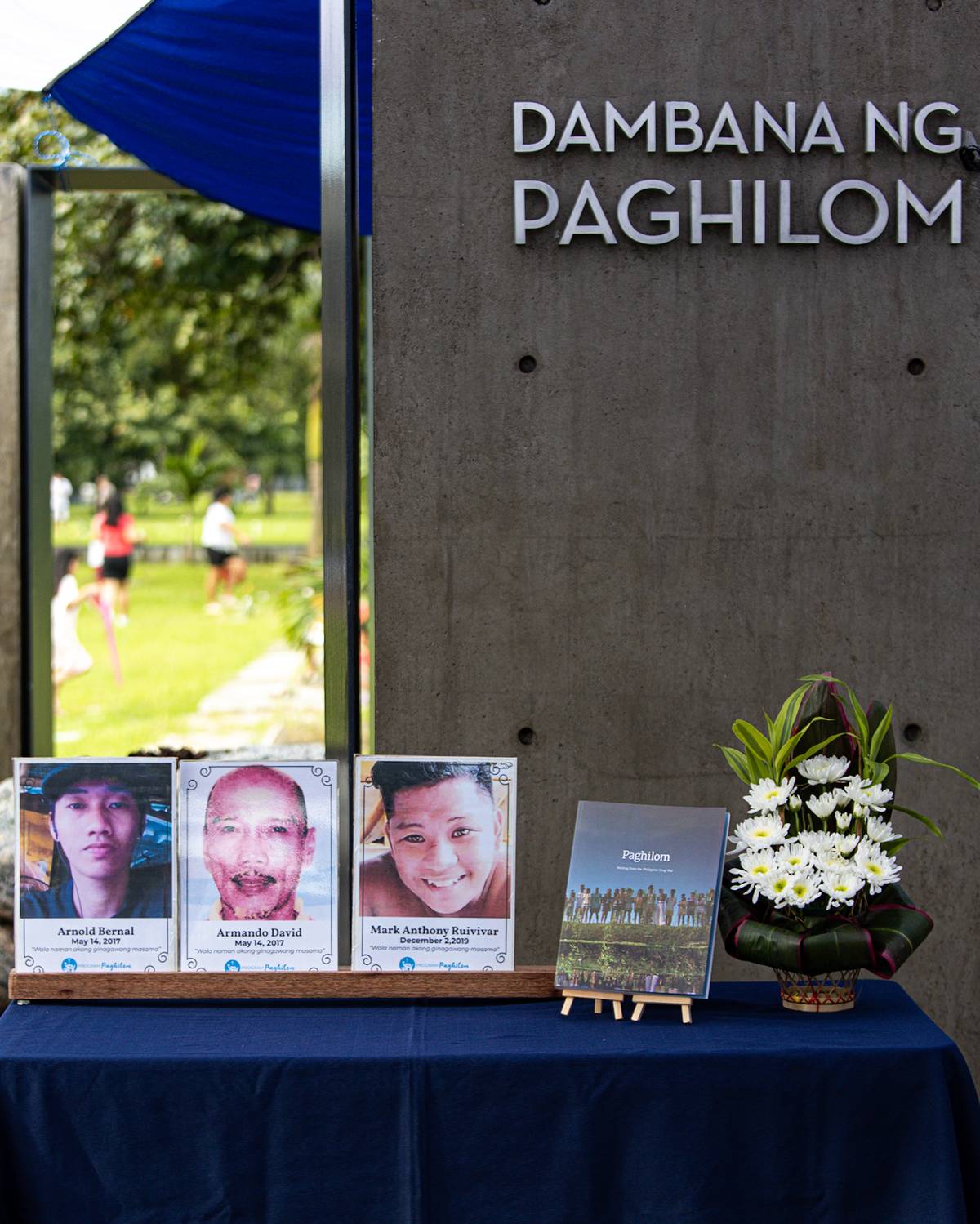 Pictures of extrajudicial killing victims are placed along the book "Paghilom," which tells the story of the former president Rodrigo Duterte's horrifying war against illegal drugs.