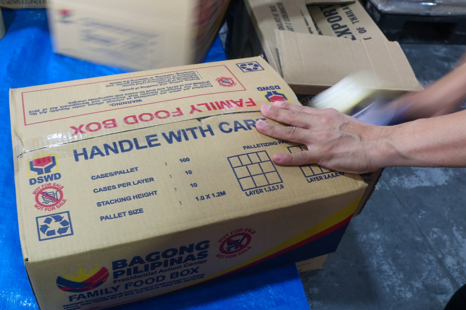 Volunteers and beneficiaries of the Tulong Panghanapbuhay sa Ating Disadvantaged Workers (TUPAD) program assemble Family Food Boxes at the Department of Social Welfare and Development warehouse in Parañaque City on World Humanitarian Day, August 19, 2025. Each food box, good for a family of five, contains 6 kilos of rice, 10 canned goods, 5 sachets of instant coffee, and 5 sachets of chocolate drinks. The initiative aims to support communities in need. World Humanitarian Day honors those who step into crises to help others.