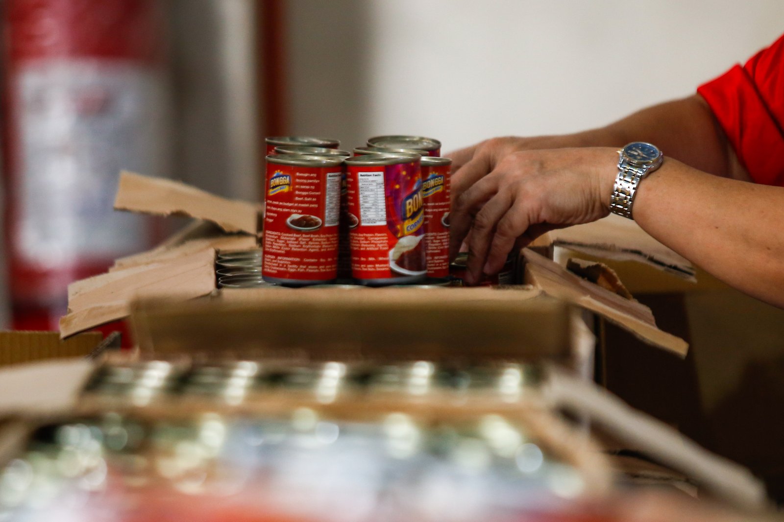 Volunteers and beneficiaries of the Tulong Panghanapbuhay sa Ating Disadvantaged Workers (TUPAD) program assemble Family Food Boxes at the Department of Social Welfare and Development warehouse in Parañaque City on World Humanitarian Day, August 19, 2025. Each food box, good for a family of five, contains 6 kilos of rice, 10 canned goods, 5 sachets of instant coffee, and 5 sachets of chocolate drinks. The initiative aims to support communities in need. World Humanitarian Day honors those who step into crises to help others.