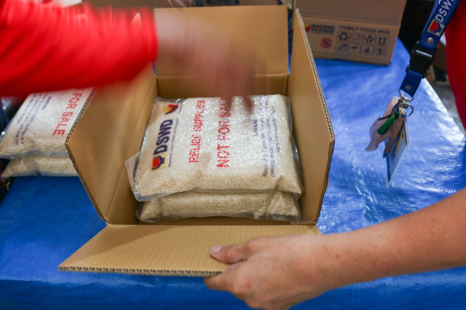 Volunteers and beneficiaries of the Tulong Panghanapbuhay sa Ating Disadvantaged Workers (TUPAD) program assemble Family Food Boxes at the Department of Social Welfare and Development warehouse in Parañaque City on World Humanitarian Day, August 19, 2025. Each food box, good for a family of five, contains 6 kilos of rice, 10 canned goods, 5 sachets of instant coffee, and 5 sachets of chocolate drinks. The initiative aims to support communities in need. World Humanitarian Day honors those who step into crises to help others.