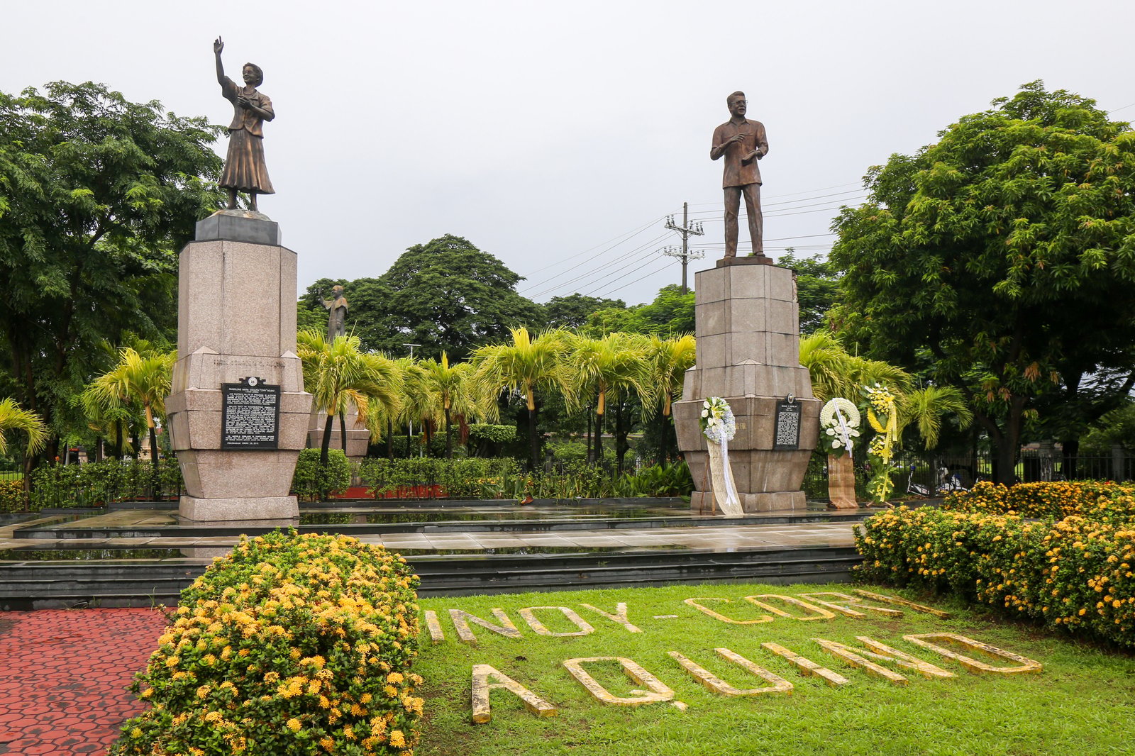 Tourist Police on bike patrol pause at the Ninoy and Cory Aquino Monument at Roxas Boulevard and Padre Burgos Avenue on Ninoy Aquino Day, August 21, 2025. Filipinos mark the 42nd anniversary of the late senator’s assassination.