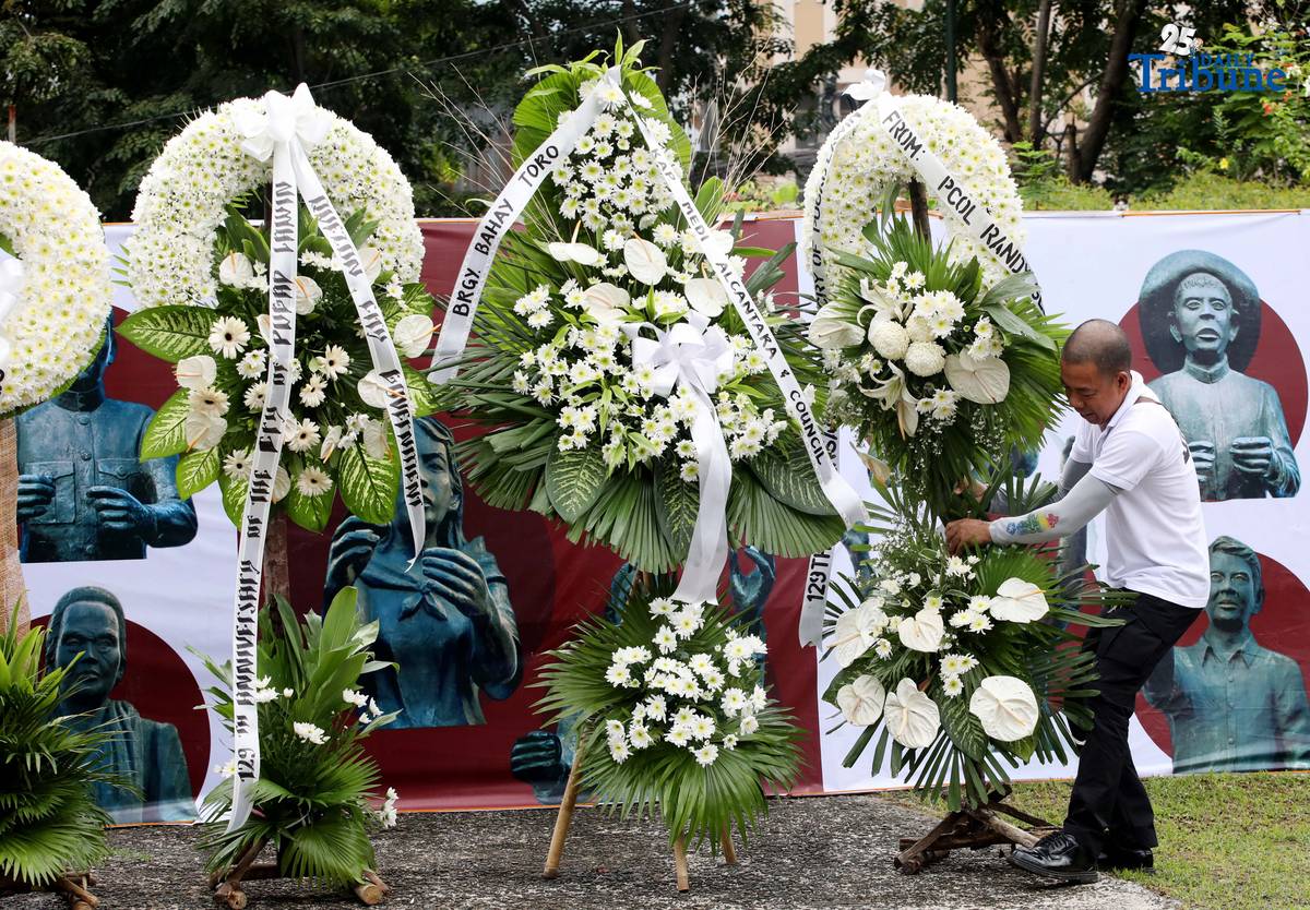 Caretakers arrange flowers offered by Quezon City officials at the Cry of Pugad Lawin Shrine on Saturday, August 23, 2025, during the 129th anniversary of the historic uprising that declared independence from Spanish colonial rule.