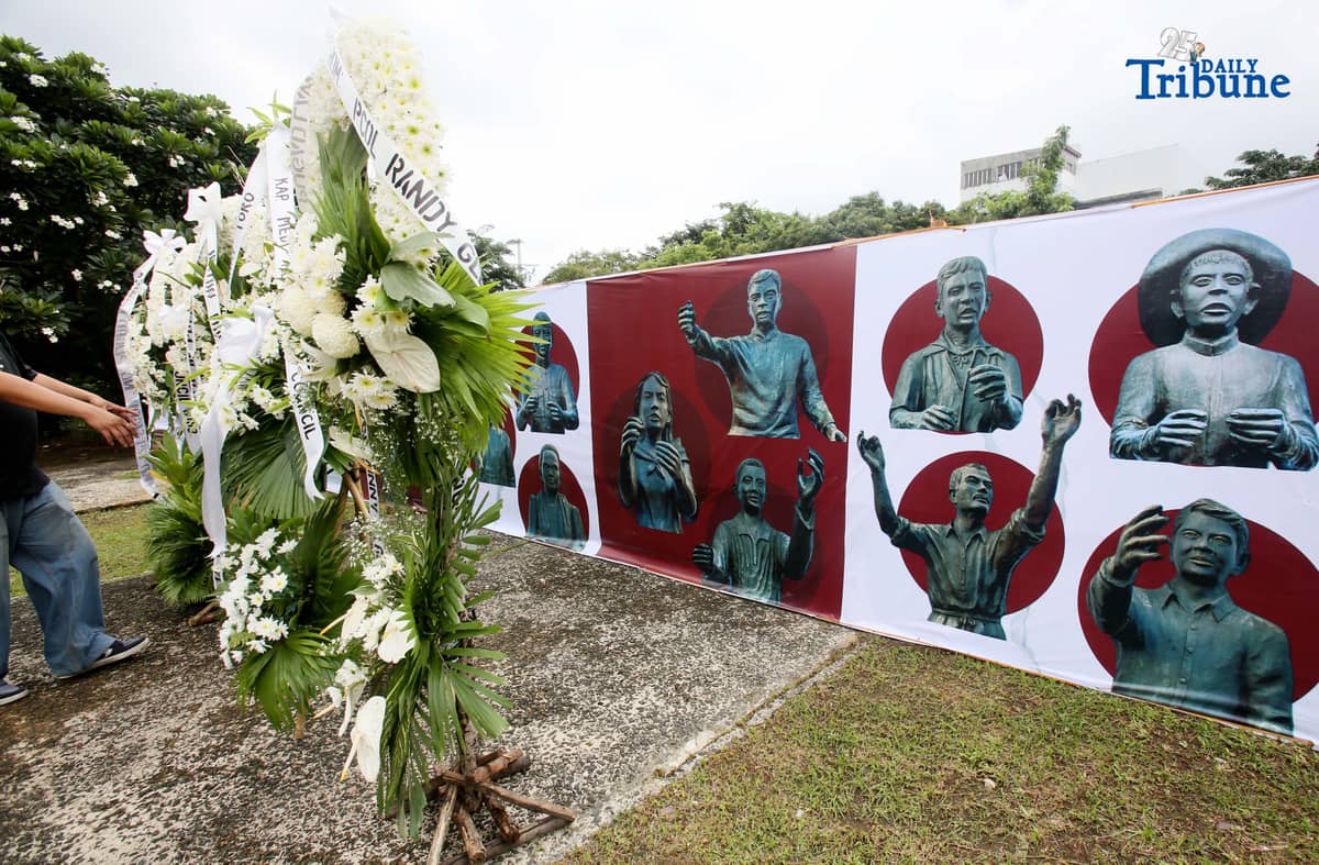 Caretakers arrange flowers offered by Quezon City officials at the Cry of Pugad Lawin Shrine on Saturday, August 23, 2025, during the 129th anniversary of the historic uprising that declared independence from Spanish colonial rule.