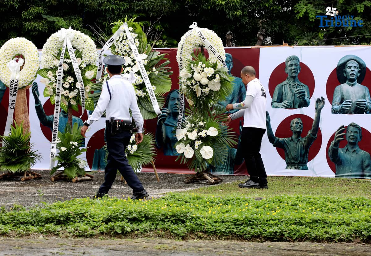 Caretakers arrange flowers offered by Quezon City officials at the Cry of Pugad Lawin Shrine on Saturday, August 23, 2025, during the 129th anniversary of the historic uprising that declared independence from Spanish colonial rule.