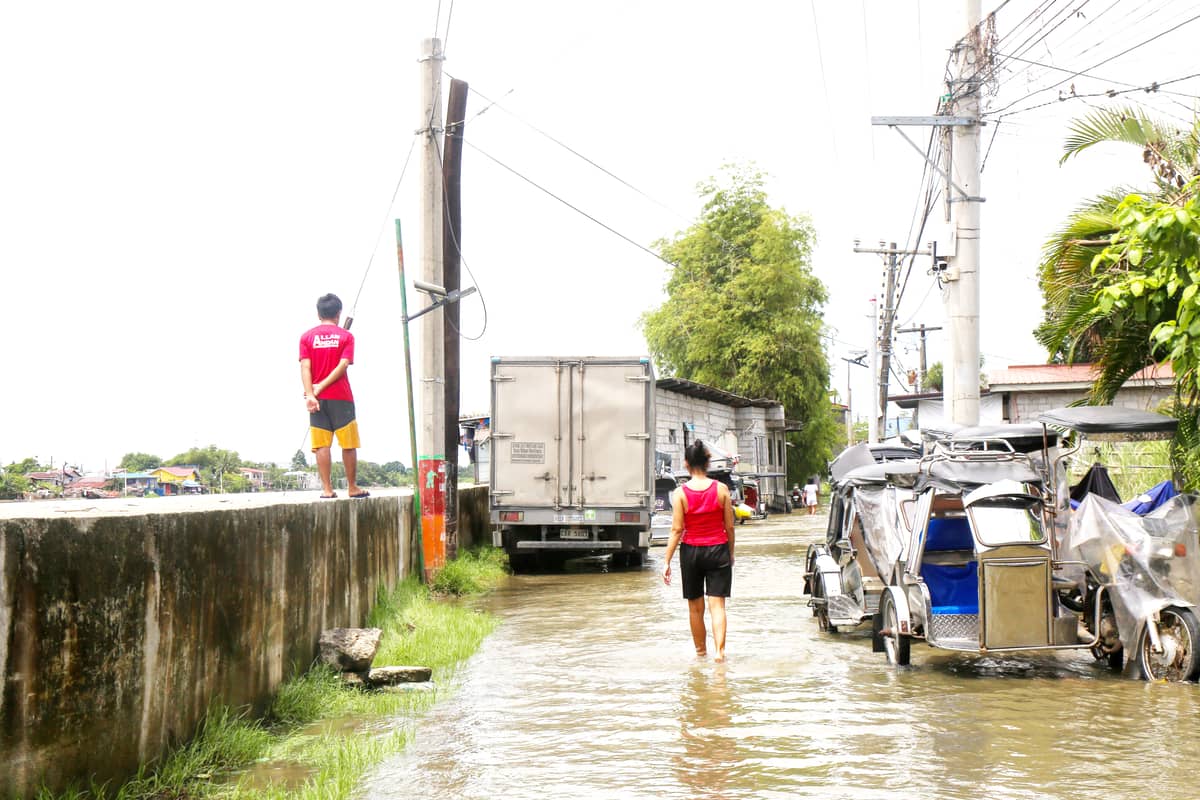 Residents of Barangay Bulusan in Calumpit, Bulacan wades through flooded street. According to the residents, it takes months for their flooded streets to subside.