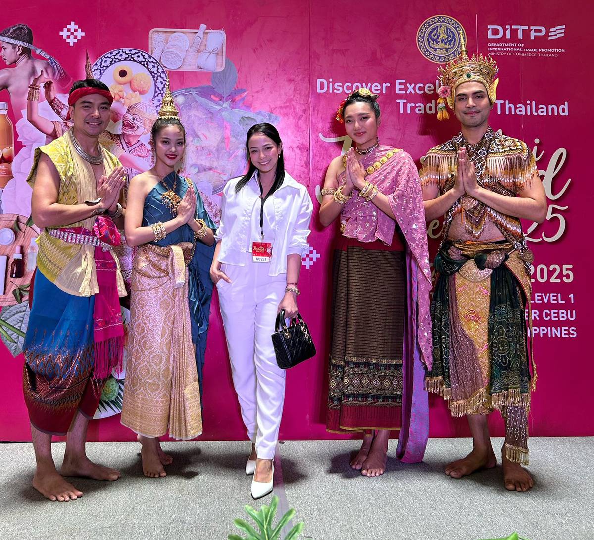 Maeyen Gomez (center) with people wearing traditional costumes of Thailand.