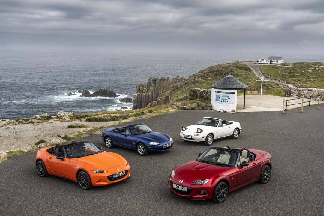 ALL four generations of the MX-5 gather by the coast, showing how the roadster has evolved while staying true to its roots.
