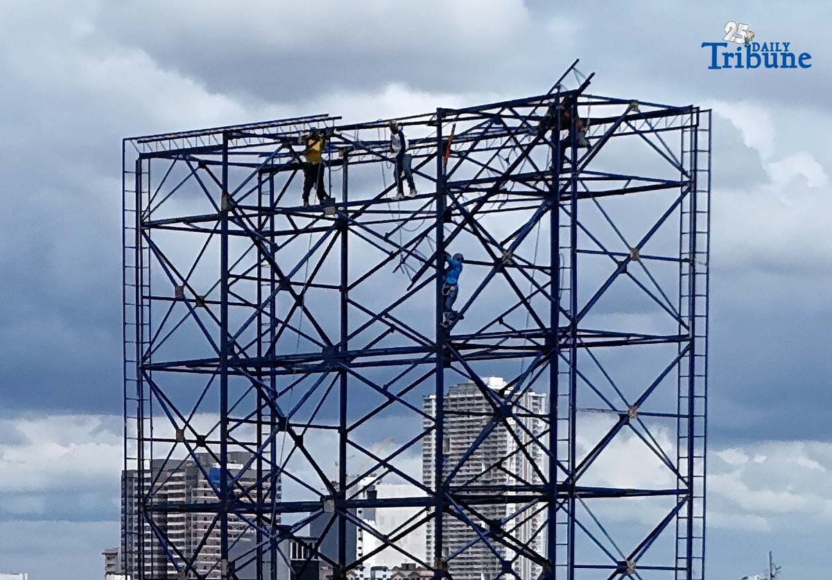 Workers were seen atop a construction billboard along EDSA in Quezon City on Thursday. On the same day, a Senate lawmaker presided over the first organizational meeting and public hearing of the Committee on Labor, Employment and Human Resource Development, which tackled proposed measures on minimum wage increases.