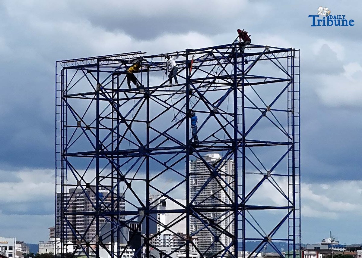 Workers were seen atop a construction billboard along EDSA in Quezon City on Thursday. On the same day, a Senate lawmaker presided over the first organizational meeting and public hearing of the Committee on Labor, Employment and Human Resource Development, which tackled proposed measures on minimum wage increases.