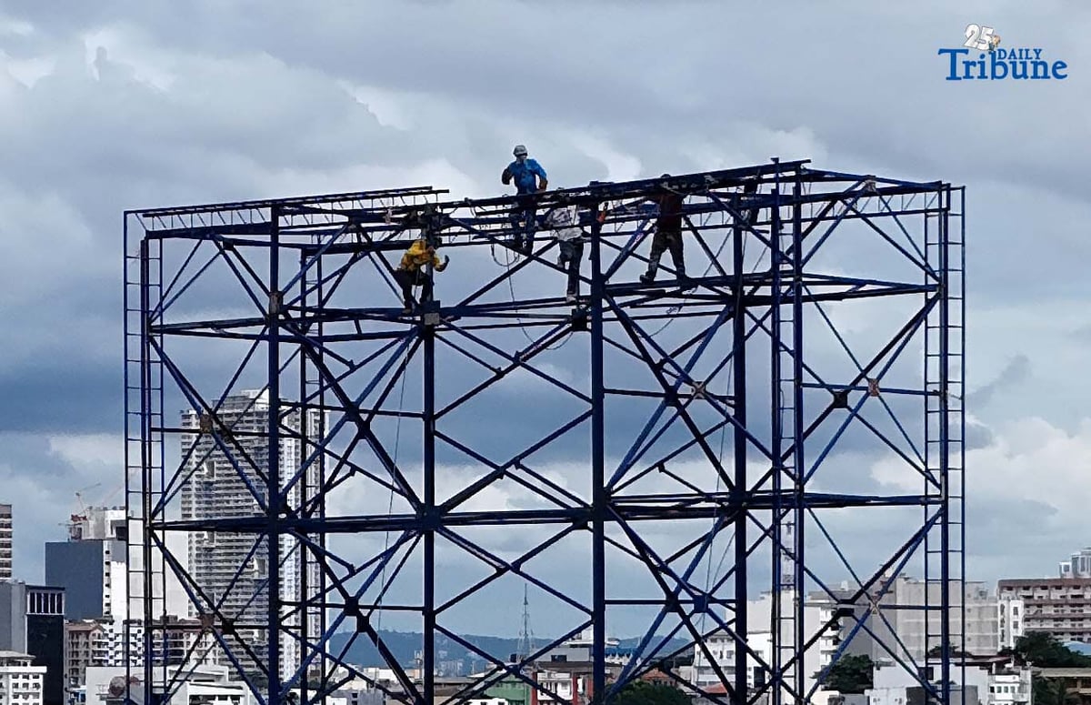 Workers were seen atop a construction billboard along EDSA in Quezon City on Thursday. On the same day, a Senate lawmaker presided over the first organizational meeting and public hearing of the Committee on Labor, Employment and Human Resource Development, which tackled proposed measures on minimum wage increases.