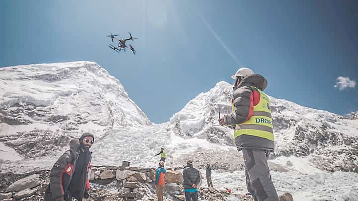 A MAN operates a heavy-lift drone to clear trash dumped at the Everest Base Camp.