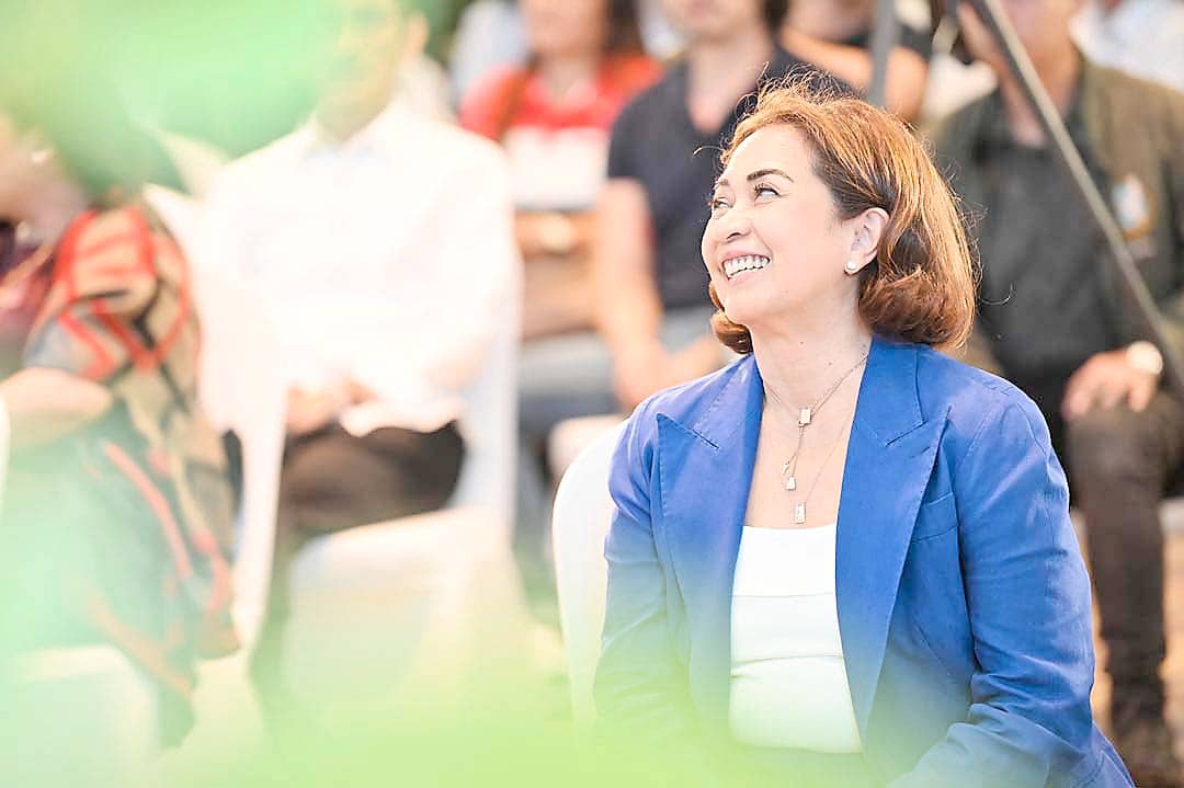Maria Fe Perez-Agudo, vice chair, president and CEO of HARI, listens with a smile as conversations on empowerment and safety unfold.