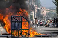 A police barricade is pictured in front of a fire set alight by demonstrators during a protest outside the Parliament in Kathmandu on September 8, 2025, against social media prohibitions and corruption by the government. Nepal police on September 8 opened fire, killing at least 17 people as thousands of young protesters took to the streets of Kathmandu demanding the government lift a social media ban and tackle corruption.