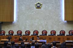 (FILES) South Korea's Supreme Court chief justice Kim Myeong-su (C) delivers the court's ruling on a conscientious objector's conviction of refusing to do mandatory military service, at the court in Seoul on November 1, 2018. South Korea's supreme court ruled on November 1 that moral and religious beliefs are valid reasons to refuse the country's mandatory military service, in a case that has implications for hundreds of conscientious objectors.