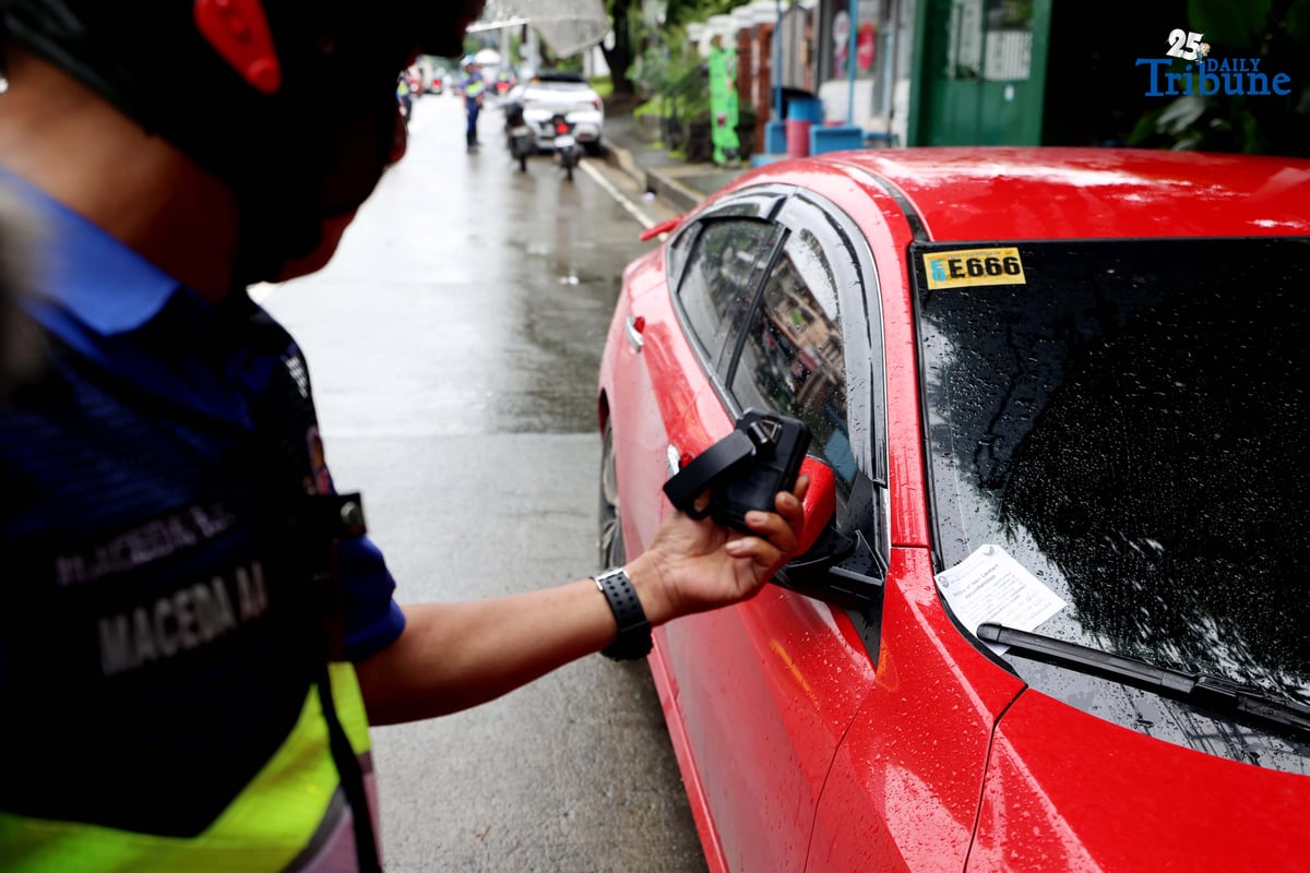 Members of the Swift Traffic Action Group (STAG) clear illegally parked vehicles along Maginhawa Street in Quezon City on Wednesday as part of the MMDA’s No Contact Apprehension Policy.