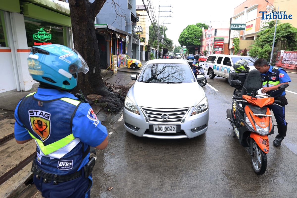 Members of the Swift Traffic Action Group (STAG) clear illegally parked vehicles along Maginhawa Street in Quezon City on Wednesday as part of the MMDA’s No Contact Apprehension Policy.