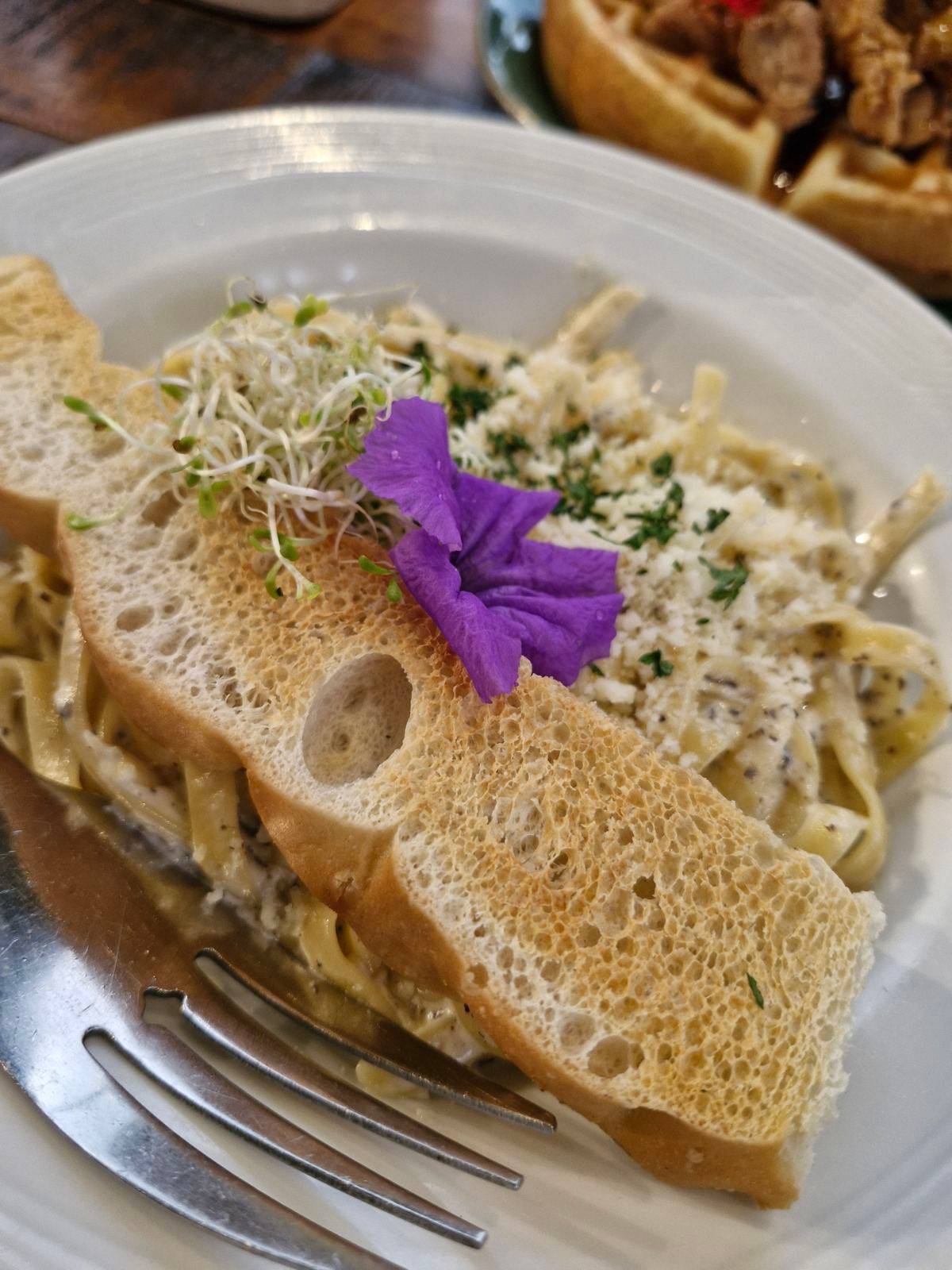 Tagliatelle con il Tartufo: It is a pasta made with black truffle paste, parmesan cheese and cream, paired with garlic bread. A true indulgence for truffle lovers.