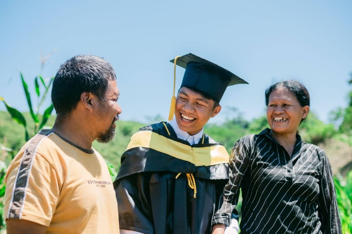 FREDIE Nanganlag Jr. (center), sixth of ten children, with his parents. After earning his agriculture degree, he’s bringing science and organic practices back home to help his family and the community.