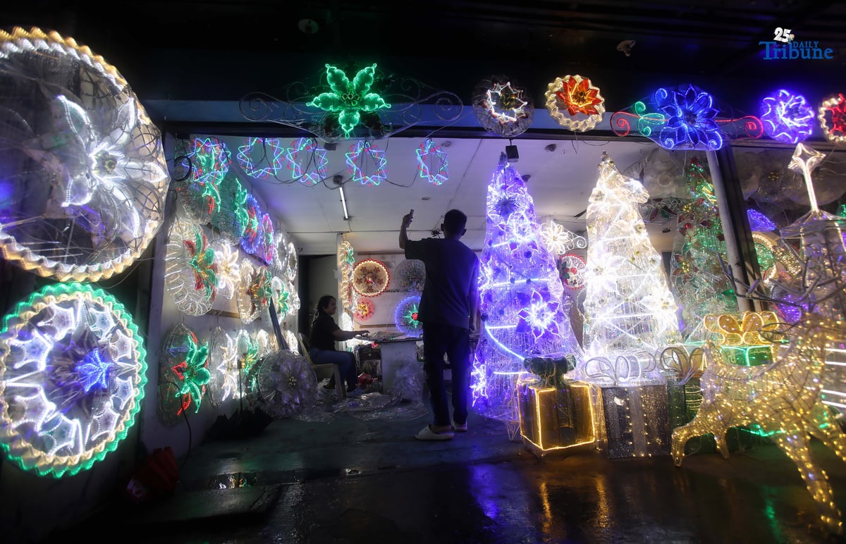 Passersby take photos of a dazzling Christmas lantern for sale at Brgy. North Fairview along Commonwealth Avenue in Quezon City on Sunday night, September 14, 2025. The Philippines celebrates the world’s longest Christmas season, which begins during the “ber” months, with the 100-day countdown to Christmas starting on September 16, 2025.