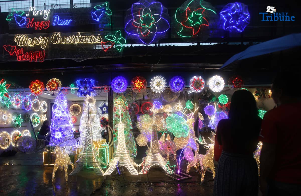 Passersby take photos of a dazzling Christmas lantern for sale at Brgy. North Fairview along Commonwealth Avenue in Quezon City on Sunday night, September 14, 2025. The Philippines celebrates the world’s longest Christmas season, which begins during the “ber” months, with the 100-day countdown to Christmas starting on September 16, 2025.