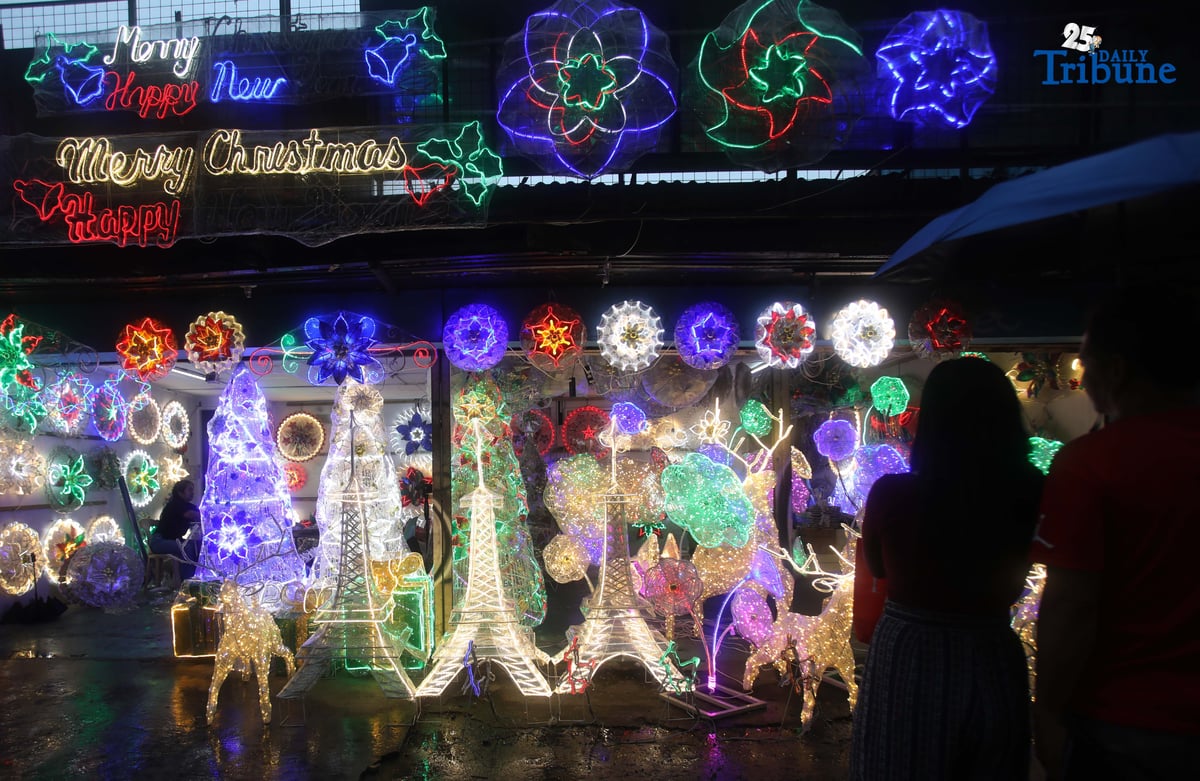 Passersby take photos of a dazzling Christmas lantern for sale at Brgy. North Fairview along Commonwealth Avenue in Quezon City on Sunday night, September 14, 2025. The Philippines celebrates the world’s longest Christmas season, which begins during the “ber” months, with the 100-day countdown to Christmas starting on September 16, 2025.