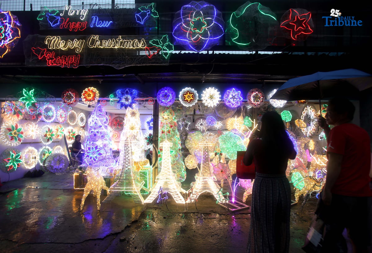 Passersby take photos of a dazzling Christmas lantern for sale at Brgy. North Fairview along Commonwealth Avenue in Quezon City on Sunday night, September 14, 2025. The Philippines celebrates the world’s longest Christmas season, which begins during the “ber” months, with the 100-day countdown to Christmas starting on September 16, 2025.