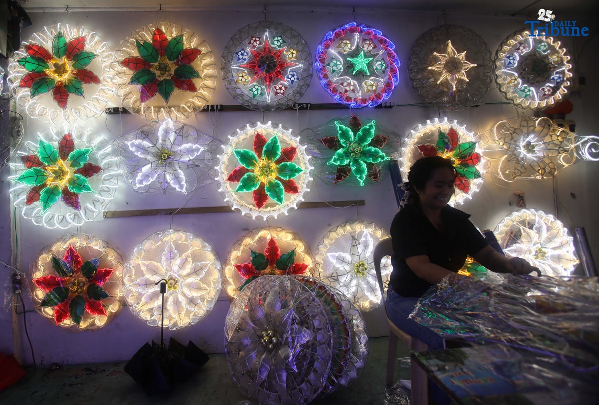 Passersby take photos of a dazzling Christmas lantern for sale at Brgy. North Fairview along Commonwealth Avenue in Quezon City on Sunday night, September 14, 2025. The Philippines celebrates the world’s longest Christmas season, which begins during the “ber” months, with the 100-day countdown to Christmas starting on September 16, 2025.