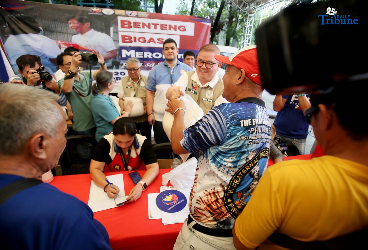 Agriculture Secretary Francisco Tiu Laurel Jr. assists in handing over P20-per-kilo rice to a tricycle driver during the rollout of the “Benteng Bigas, Meron Na!” project for the transport sector at the Kadiwa ng Pangulo Center in BAI, Quezon City on Tuesday.