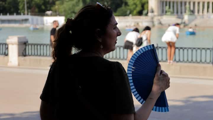 A woman uses a hand fan in a park during the first heatwave of the summer in Madrid, on June 28, 2025. Starting June 28, 2025 southern Europe will once again face extreme temperatures exceeding 40°C. Scientists warn that periods of extreme heat will become longer, more frequent and more intense as human-induced climate change accelerates.