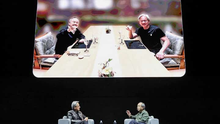 Nvidia CEO Jensen Huang (L) speaks with the CEO of the SoftBank Group Masayoshi Son during an AI event in Tokyo on November 13, 2024.