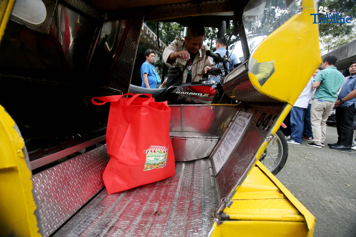 A tricycle driver, a member of a transport group, rides away after buying 10 kilos of rice at P20 per kilo during the rollout of the “Benteng Bigas, Meron Na!” Rice Project for the transport sector. The distribution was held at the Kadiwa ng Pangulo Center in BAI, Quezon City on Tuesday.