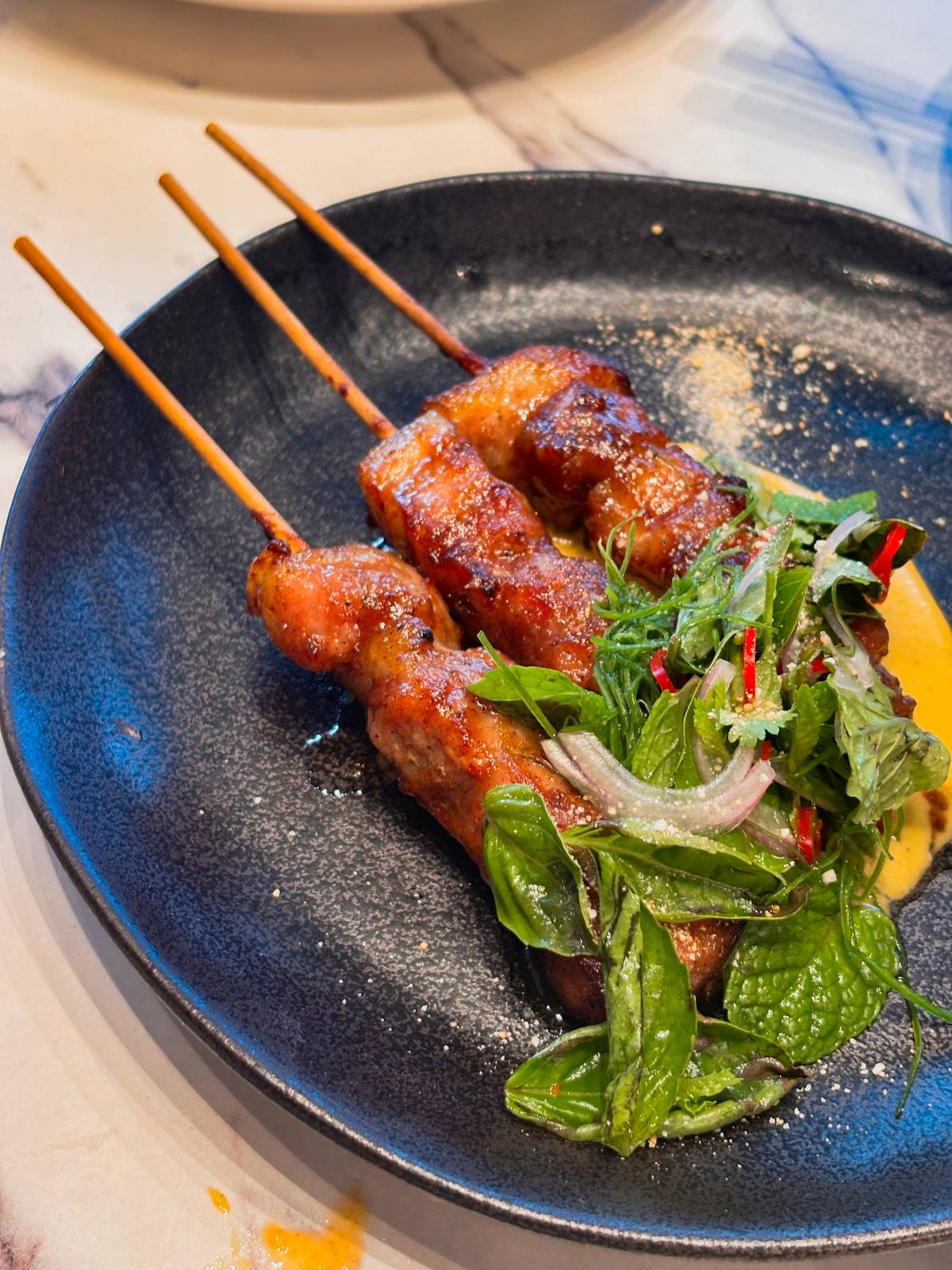 Skewered tamarind-glazed pork belly, salted egg curry sauce.