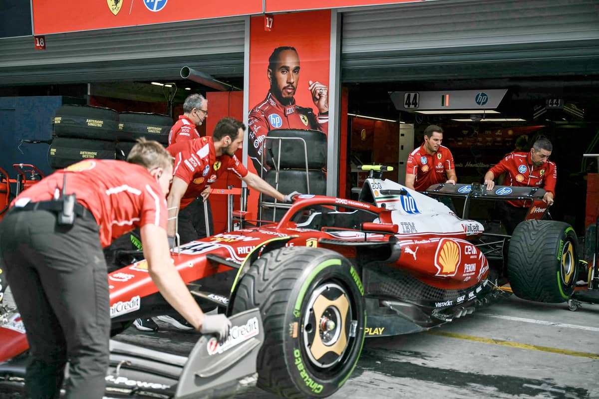 Ferrari team mechanics examine Ferrari’s British driver Lewis Hamilton’s car in the pit lane at the Monza circuit.