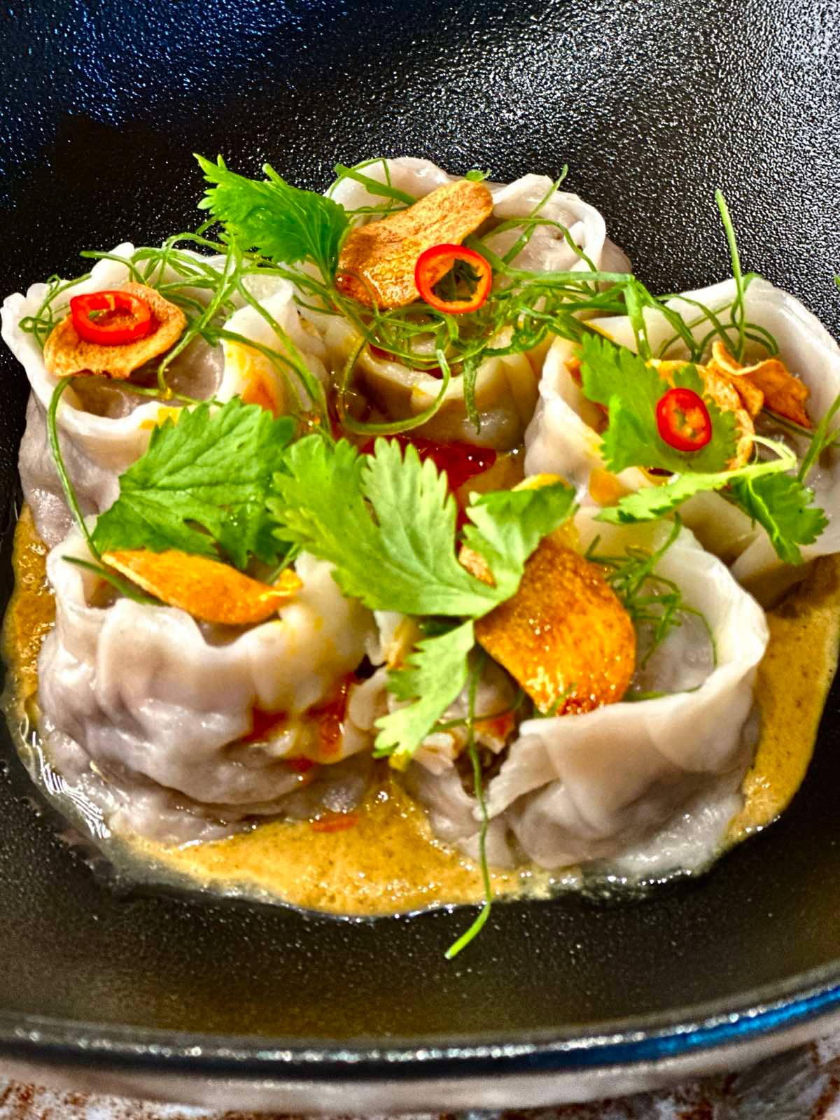 Wagyu beef dumplings, Szechuan oil, Gaeng Gati yellow curry sauce.
