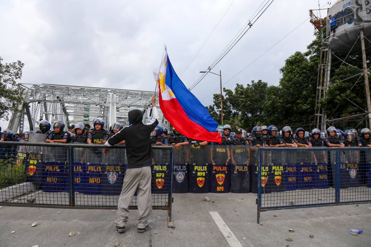 Rally to the Flag Police block Ayala Bridge as protesters
press toward Malacañang, raging against billions lost to
corruption.