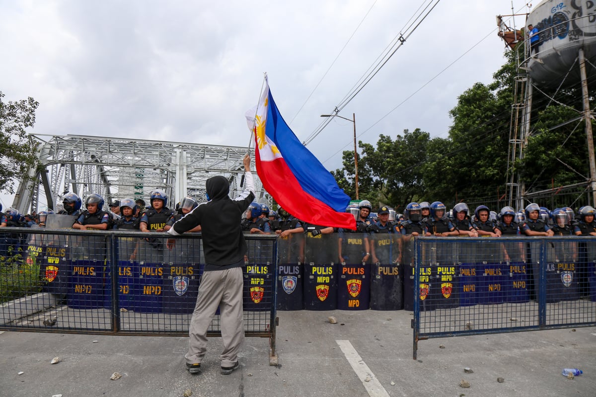 Rally to the Flag Police block Ayala Bridge as protesters
press toward Malacañang, raging against billions lost to
corruption.