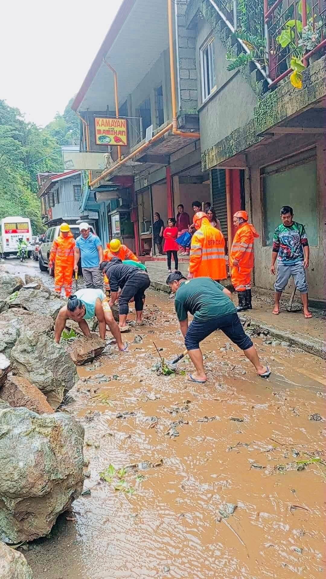 Personnel of different government agencies and department s, Barangay local government units and community volunteers clean up the roads and areas of fallen trees, muds, rocks and other debris on September 23, 2025 as typhoon "Nando" exited the country's area of responsibility. | Aldwin Quitasol. Photos Courtesy of BFP Mountain Province, LGU Barlig, Mountain Province DRRMO.