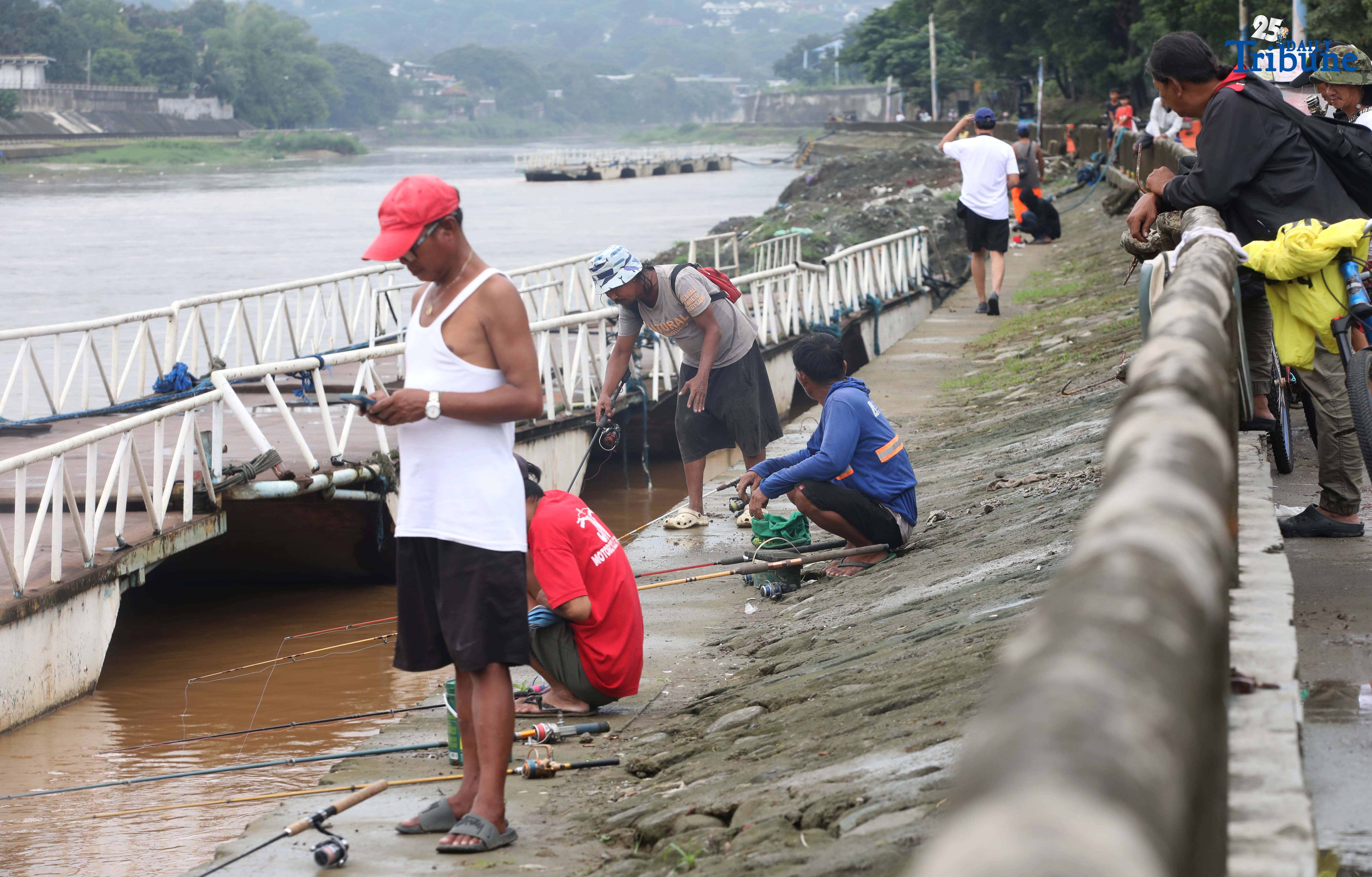 Residents fish in Marikina river as 'Opong' weakens
