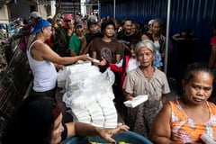 Photos show people lining up for food packs in Manila