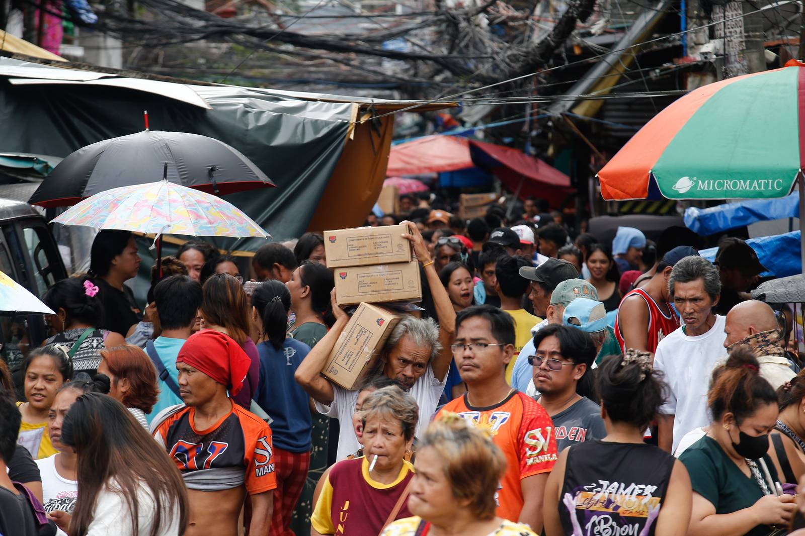 Residents of Happyland in Tondo, Manila, queue for Department of Social Welfare and Development family food packs on Saturday morning. The community was struck by a fire on September 13 that escalated to Task Force Bravo.