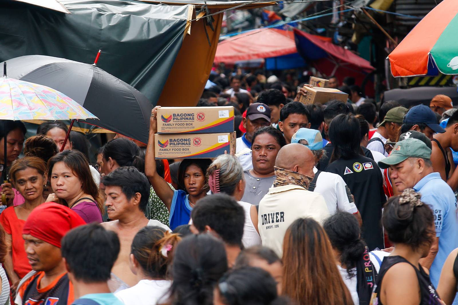 Residents of Happyland in Tondo, Manila, queue for Department of Social Welfare and Development family food packs on Saturday morning. The community was struck by a fire on September 13 that escalated to Task Force Bravo.